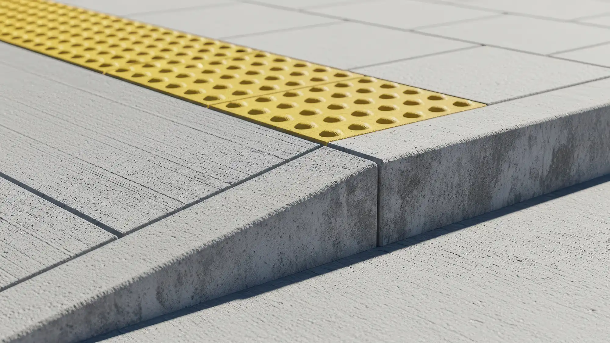 Close-up of a textured gray pavement with a bright yellow tactile warning strip for accessibility.